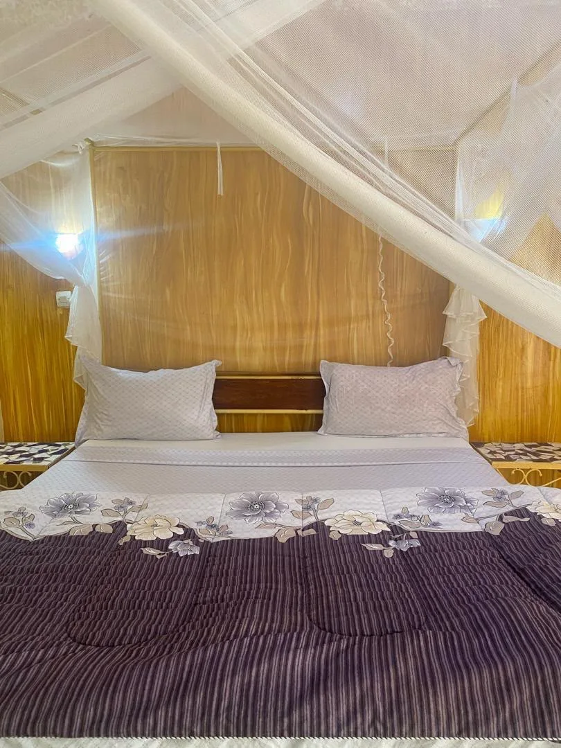 Chambre avec lit et moustiquaire au Lac Rose